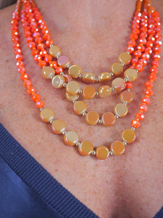 OFF#DLY 4 Strang Kette orange auf einem Frauenhals, ca. 30 cm lang, aus Glasperlen gefertigt, präsentiert als modisches Schmuckstück.