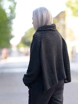 Eine Frau trägt den Rundholz Pulli 3420702 black, einen Grobstrickpullover mit Schalkragen. Der Pullover wirkt oversized und ist Teil eines lässigen, modischen Streetwear-Looks.