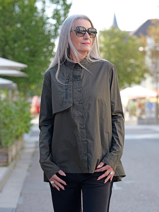 Frau mit grauen Haaren trägt Rundholz Bluse Jungle Print mit Kopfleiste und Brusttasche. Die Bluse hat eine A-Linie mit schönen Falten. Modell ist 172 cm groß und trägt Größe S.