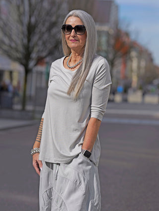 Nahaufnahme eines Rundholz T-Shirt 3260501 in Grau mit großem Rundhalsausschnitt und 3/4 Ärmeln, präsentiert in einem modischen Street-Fashion-Kontext als vielseitiges Basic für jeden Look.