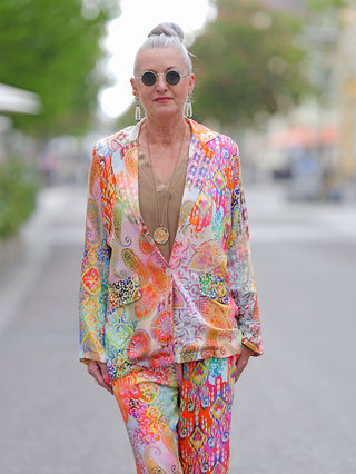 Frau trägt Emily Damenblazer Multi, einen lässigen Blusen-Blazer mit Krempelärmeln aus fließender Viskose, kombiniert mit Sonnenbrille und goldener Halskette.