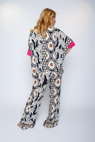 Emily Oversized Bluse in pink/sand mit Ethno-Print, boxy Oversize-Design und kleiner Ärmelblende, aus fließender Viskose, getragen von einer Person in einem modischen Outfit.