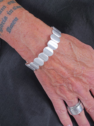 Person trägt das OFF#DLY Armband Naomi schmal in Silber, ein elegantes, schmales Metallarmband am Handgelenk, das etwa 1,5 cm breit ist und nickelfrei.