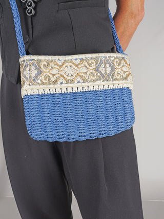 OFF#DLY Crossbag Bast blue, getragen von einer Person, zeigt eine stilvolle Baststruktur mit Zipper. Die Tasche ist kompakt und modisch, perfekt für den täglichen Gebrauch. Größe: 25x18x5 cm.