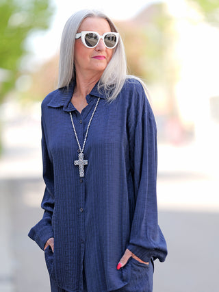 Frau trägt die OFF#DLY Summer Shirt Teresa blue, eine langärmelige Bluse mit Knopfleiste und elegantem Design. Die Kombination aus Rayon und Viskose sorgt für besonderen Tragekomfort.