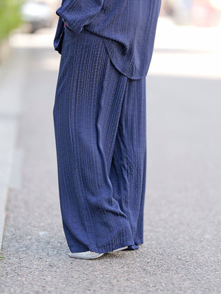 Person trägt OFF#DLY Summerpant Teresa blue, eine weite Sommerhose mit Gummibund, ideal für Komfort und Stil.