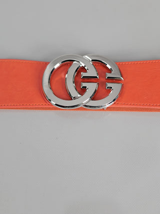 OFF#DLY Gürtel GG orange/silber zeigt einen eleganten, korallfarbenen Ledergürtel mit einer glänzenden silbernen Schnalle aus zwei ineinandergreifenden G-Buchstaben, ideal zur Vervollständigung stilvoller Outfits.