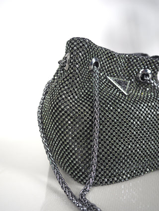 Guess Bag Lua Mini black mit silbernen Kettenhenkeln, goldfarbenen Metallbeschlägen und Strassbesatz. Sichtbar ist das Metall-Logo-Dreieck mit Schmuckapplikationen. Maße: 15x15x10 cm.