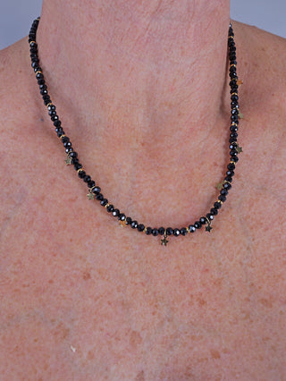 Person trägt das OFF#DLY Collier Star black/gold, eine kurze, feine Kette mit kleinen Anhängern, sichtbar am Hals. Schmuckstück aus nickelfreiem Metall, Länge 20 cm.