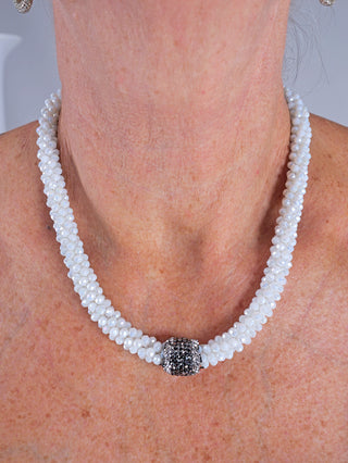 OFF#DLY Kette Luisa white, eine Glasperlenkette mit Magnetverschluss, getragen um den Hals einer Person, zeigt feine Details und elegante Gestaltung. Länge 20 cm.