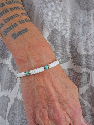 Nahaufnahme des OFF#DLY Armbands am Handgelenk einer Person, kombiniert mit einem Tattoo. Das Armband besteht aus nickelfreiem Metall und Tonstein, präsentiert in einem stilvollen Design.