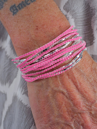 Nahaufnahme des OFF#DLY Monika Armband Set pink, bestehend aus einem 12-teiligen Armbandset aus nickelfreiem Metall und Glas, das stilvoll am Handgelenk präsentiert wird.