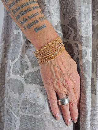 OFF#DLY Monika Armband Set caramel, gezeigt am Handgelenk mit Tattoo. Enthält mehrere Armbänder und einen Ring. Material: Metall nickelfrei/Glas. Set umfasst 12 Teile. Größe: One Size.
