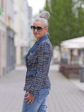 Eine Frau trägt den OFF#DLY Denim Blazer Blue, einen sportlichen Kurzblazer mit schmalem Schnitt, sichtbar mit seitlichen Taschen und doppelter Knopfreihe.