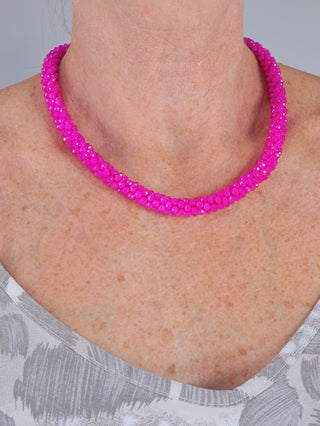 OFF#DLY Glaskette Ulla pink, eine glänzende Glaskugelkette um den Hals einer Person, Länge ca. 22 cm mit Verlängerung.