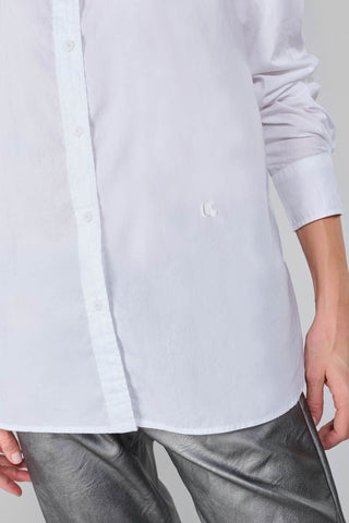 Person trägt das Shirt Femme Jama mit klassischem Kragen und langen Ärmeln. Das Hemd zeigt dezente Stickereien und Knöpfe auf der Rückseite, passend für einen klassischen Look.