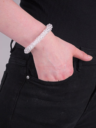 Hand trägt das OFF#DLY Armband Scarlett klar, ein Glasarmband mit elastischem Gummiband, sichtbar im Detail am Handgelenk. Perfekt für modische Akzente und elegantes Tragen.