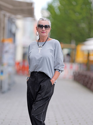 Frau mit Sonnenbrille und Halskette trägt das True Religion Wide Crew Tee Reflective, ein oversized Rundhalssweater.