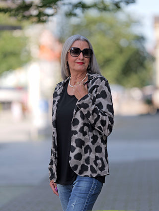 Frau trägt Doris Streich Blazer Animal mit Leopardenmuster, offenem Design ohne Knöpfe und Taschen, kombiniert mit einer Sonnenbrille, betont modischen Streetstyle.