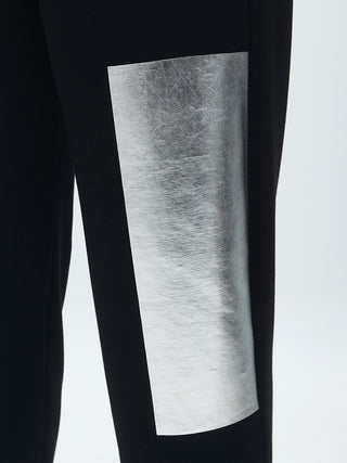 MAT Hose 2041 black silver, Joggpant mit elastischem Bund und silberglänzender Applikation, aus Viskose-Mix. Nahaufnahme zeigt schwarzen Stoff mit silbernem Streifen auf Hosenbein.
