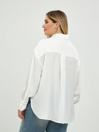 Eine Frau trägt die MAT Bluse 3060 in Weiß, kombiniert mit blauer Jeans. Die Bluse besteht aus 100% Polyester und hat lange Ärmel, ideal für einen lässigen Look in großen Größen.