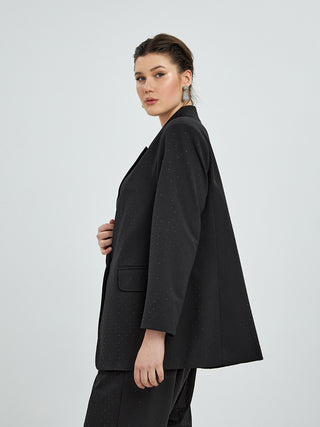MAT Blazer 4033 black Strass: Eine Frau trägt einen schwarzen Blazer mit einem modernen Schnitt, sichtbar sind Details wie eine Hand auf dem Anzug und ein eleganter Kragen.