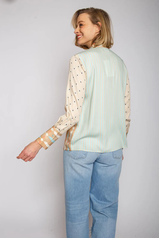 Emily Bluse 796 sand/blue: Frau trägt gestreifte Hemdbluse mit geometrischem Muster und langen Ärmeln in Viskose-Satin, kombiniert mit blauen Jeans. Bluse fällt normal aus, Modellgröße 36.