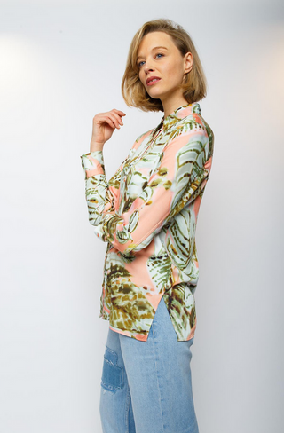 Emily Bluse 493 salmon/khaki: Frau trägt eine Hemdbluse mit floralem Aquarell-Print, durchgehender Knopfleiste und langen Ärmeln. Der fließende Viskose Satin verleiht der Bluse ein elegantes Aussehen.