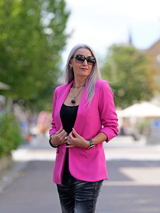 Frau trägt den OFF#DLY Blazer Pamela Pink mit 3/4 Ärmeln, schmal geschnitten, aus Viskosemischung. Sie kombiniert ihn mit Sonnenbrille und modischem Stil.