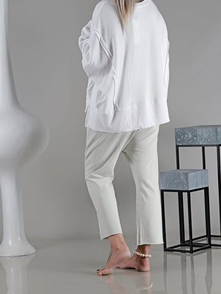 Eine Person trägt die Cotton Candy Pant Hedwig, eine weiche Hose mit seitlichen Eingrifftaschen, die einen hohen Tragekomfort bietet. Das Modell ist lässig und modisch geschnitten.