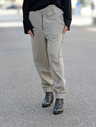 Person trägt ThomKrom WST 384 Pant mit elastischem Bund und Paspel-Details, kombiniert mit schwarzen Stiefeln. Die lässige Sweathose aus weicher Baumwoll-Qualität zeigt modernen Street-Fashion-Stil.