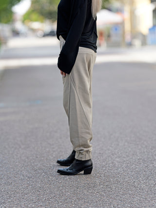Person trägt ThomKrom WST 384 Pant, eine lässige Sweathose mit elastischem Bündchen und Paspel-Details. Die Hose besteht aus weicher Baumwoll-Sweat-Qualität und zeigt modische, komfortable Passform.