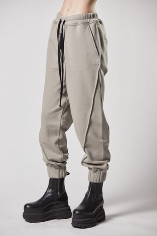 Eine Person trägt die ThomKrom WST 384 Pant, eine lässige Sweatpants mit elastischem Bündchen und Paspel-Details, kombiniert mit schwarzen Boots.