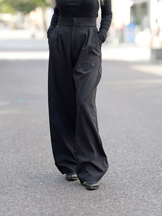 ThomKrom WST390 Pant: Person trägt weite, hoch taillierte schwarze Hosen mit umgeschlagenem Saumdetail, präsentiert in einem straßentauglichen, lässigen Stil. Baumwollmischung, in der Türkei hergestellt.