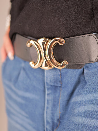 Nahaufnahme des Gürtel CC Groß schwarz mit einer auffälligen goldfarbenen Schnalle. Der elastische Taillengürtel ergänzt stilvoll Outfits und ist aus Polyester und Metall gefertigt.