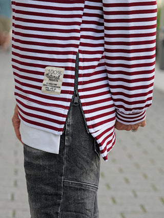 Person trägt das OFF#DLY Ringelshirt Nena burgundy/white mit roten und weißen Streifen und seitlichem Zipper, schmales Longsleeve-Design, passend bis Größe 40.