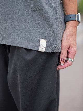 Nahaufnahme einer Hand, die das weiche Langarmshirt Cotton Candy Tee Umut mit O-Neck-Ausschnitt trägt, kombiniert mit einem modischen Accessoire, wie einem Ring oder einer Uhr, sichtbar.
