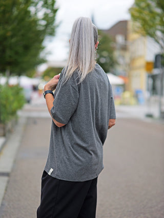 Person mit grauen Haaren trägt das Cotton Candy Tee Umut, ein langärmeliges, lässiges Shirt mit O-Neck-Ausschnitt, perfekt sitzend und bequem für jede Gelegenheit.