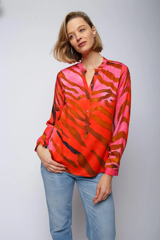 Emily Bluse red pink zebra, lässige Shirtbluse mit Stehkragen und halber Knopfleiste, Langarm mit schmalen Manschetten, auffälliger Zebra-Print. Model trägt sie mit blauer Jeans.