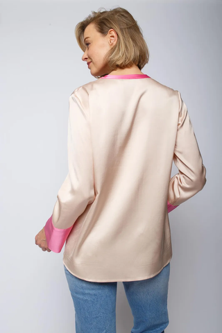 Emily Bluse sand: Frau trägt elegante Bluse mit kleinem Kragen und V-Ausschnitt. Ärmel mit breiter Saumblende. Leicht fließend, perfekt für modische Anlässe.