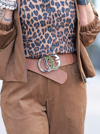 Person trägt OFF#DLY Pant Clara, eine Velours-Optik-Hose mit weitem Bein und seitlichen Einschubtaschen. Kombiniert mit einem Leopardenmuster-Oberteil, verleiht sie einen stilvollen Look.