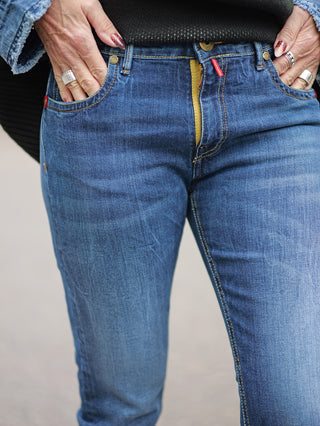 TAKE 2 Chiba Denim slim Jeans, getragen von einer Person mit Händen in den Taschen, zeigt die schmale 5-Pocket-Form und Midblue Waschung. Ein Ring an der Hand ist sichtbar.