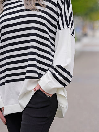 Philomena Pulli WL152 streifen, getragen von einer Person. Der Pullover zeigt ein Streifenmuster und hat einen V-Ausschnitt, passend für einen lässigen Streetstyle.