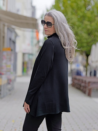 Philomena Pulli WL103 black: Frau in schwarzem Langarmshirt mit Rollkragen und Sonnenbrille, langer grauer Haare, trägt Größe S. Perfekt für Street-Fashion-Looks.