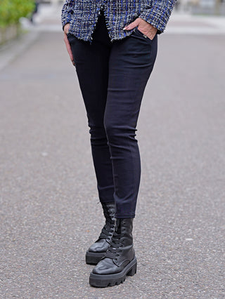 OFF#DLY Legging Sonja dunkelblau getragen von einer Person, kombiniert mit schwarzen Stiefeln. Die Leggings wirken bequem und haben seitliche Einschubtaschen, ideal für einen lässigen Look.