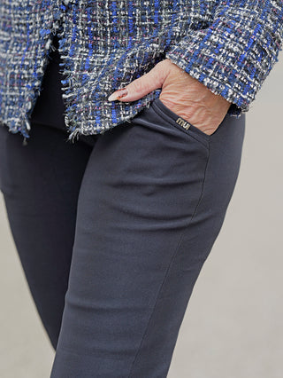 Nahaufnahme der OFF#DLY Legging Sonja dunkelblau, zeigt die Hand einer Frau in der seitlichen Einschubtasche der dunkelblauen Leggings aus Viskose-Baumwolle, getragen in Größe S/M.