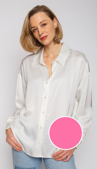Emily Bluse pink: Eine Frau trägt eine weiße Hemdbluse mit Knopfleiste und überschnittenen Schultern, aus fließendem Viskose Satin, gezeigt in einer modernen, lässigen Passform.