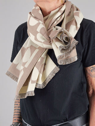 Eine Person trägt den OFF#DLY Schal Heart beige, einen eleganten, weichen Schal aus 50% Viskose und 50% Polyester, stilvoll um den Hals gewickelt.