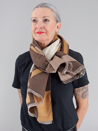 Eine Frau trägt den OFF#DLY Schal Stelvio braun, einen großen, weichen Viskoseschal. Der Schal ist um ihren Hals drapiert und unterstreicht ihren modischen Look.
