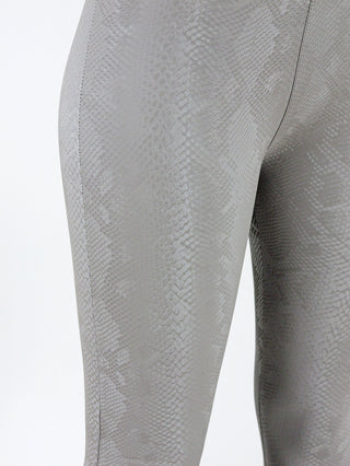 Nahaufnahme der OFF#DLY Snake Legging taupe, die eine schlangenartige Struktur zeigt. Sie ist eng anliegend und aus einem Polyester-Elastan-Mix gefertigt, ideal für einen modernen, stilvollen Look.